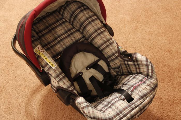 A car seat sitting on a carpeted floor